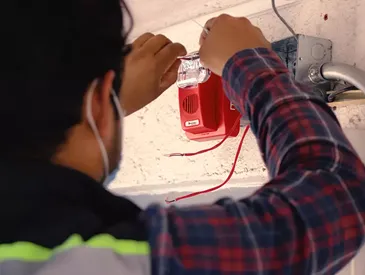 Sistema de alarma y sensor contra incendio instalado en el techo de un corporativo para garantizar evacuación segura.